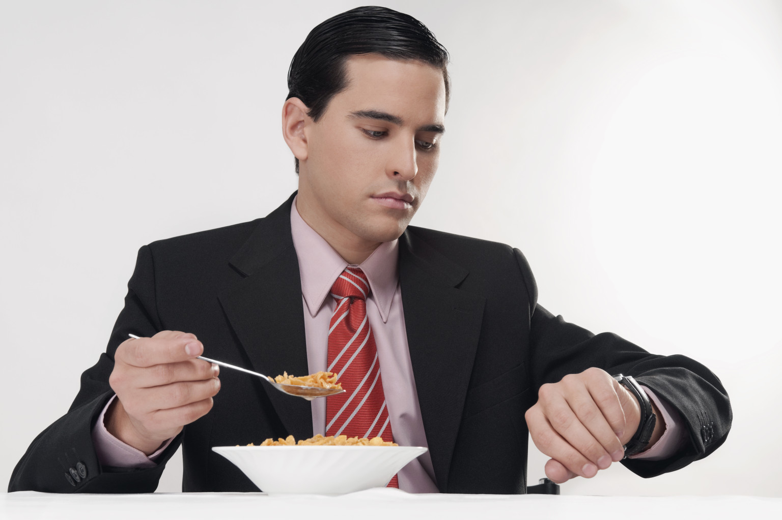 Businessman checking the time at breakfast table